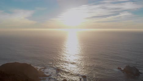 Flying-away-from-the-sunset-over-tall-cliffs-along-coastal-highway