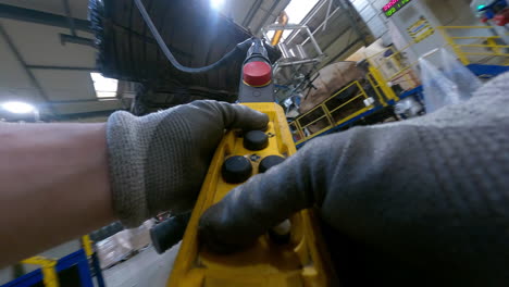 crane being operated by a controller in a manufacturing facility, production industry