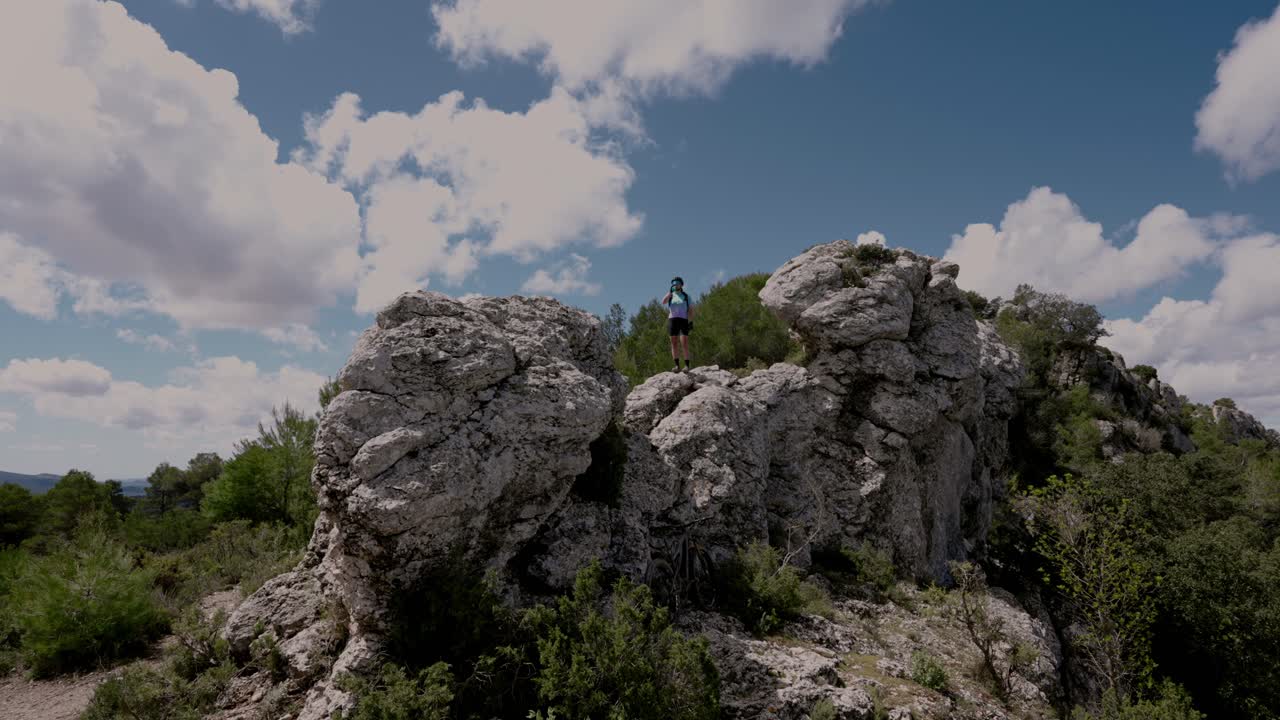 화창한 날 산 정상에서 자전거를 타는 사람이 술을 마신다