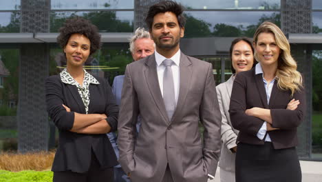 retrato de un equipo de negocios multicultural sonriente fuera de un moderno edificio de oficinas