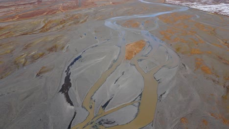 confluence of muddy rivers in brown glacial plains with mud and silt