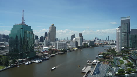 A-variety-of-boat-traffic-speeds-along-the-Chao-Phraya-River,-Bangkok,Thailand