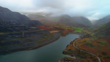 Dinorwic-quarry-with-mountains-shrouded-in-fog-in-background,-Wales,-UK