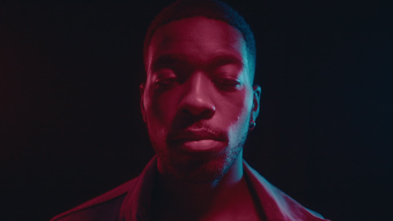 Handsome Black Man Posing in Dark Studio with Neon Lights