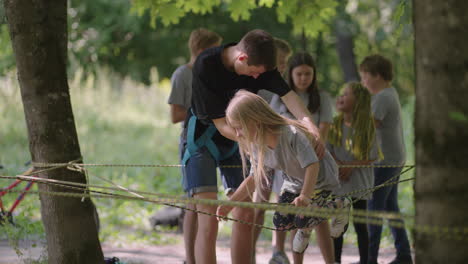 in the summer camp my daughter learns to overcome rope obstacles and rock climbing. teaching children about tourism and hiking