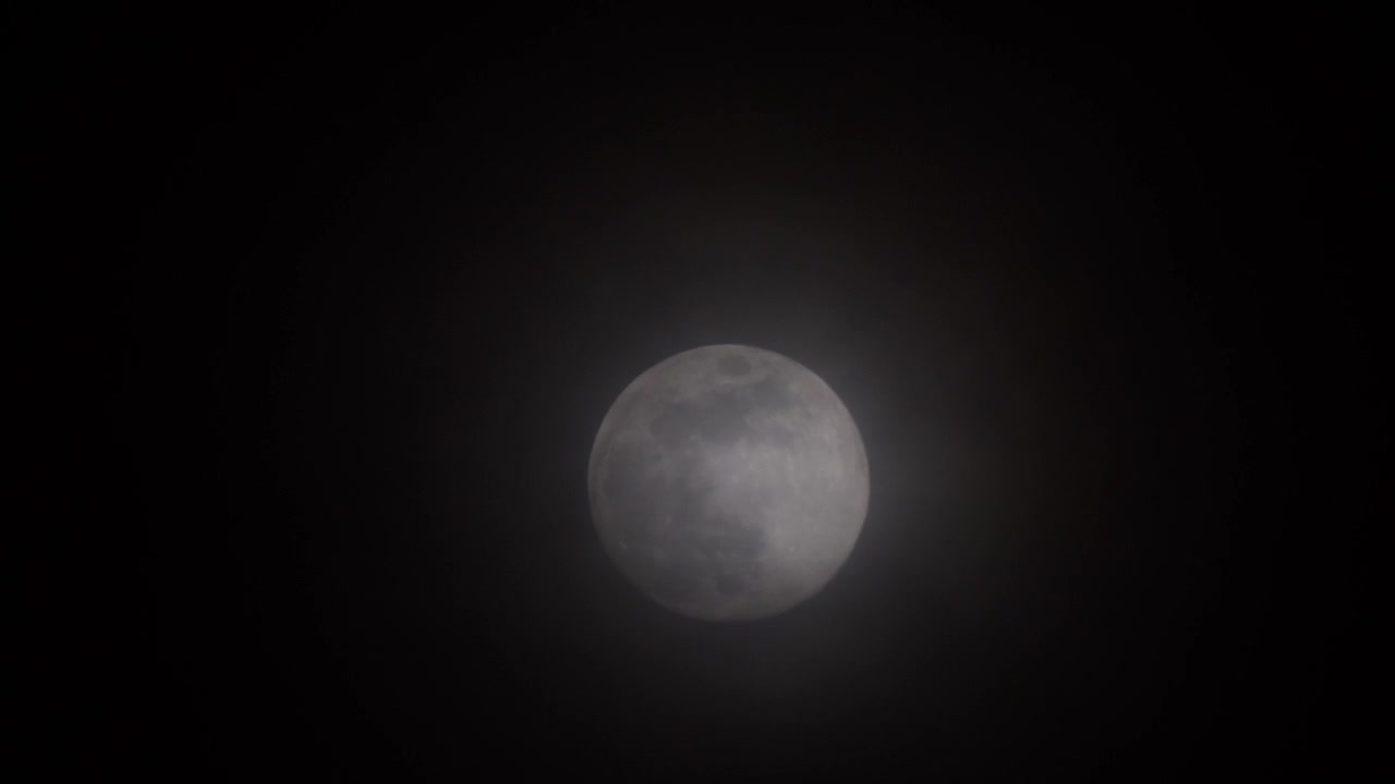 Close-up com teleobjetiva de lua cheia brilhante com nuvens finas se movendo no céu escuro. Conceito para astronomia, atmosfera noturna, fases lunares, mistério e espaço.