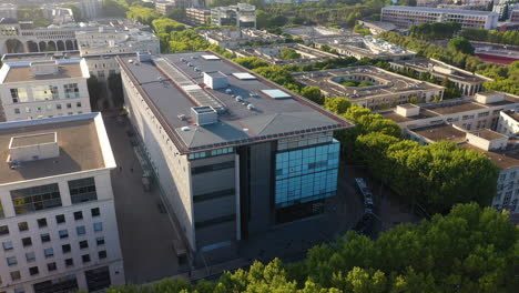 blue tramway passing along modern buildings and green trees on a boulevard