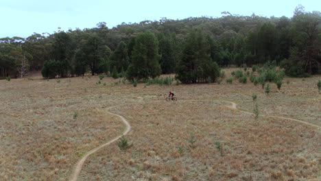 Dron-Rastreando-A-Una-Ciclista-De-Montaña-A-Lo-Largo-De-Los-Senderos-En-Australia