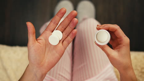 woman taking pills in pajamas