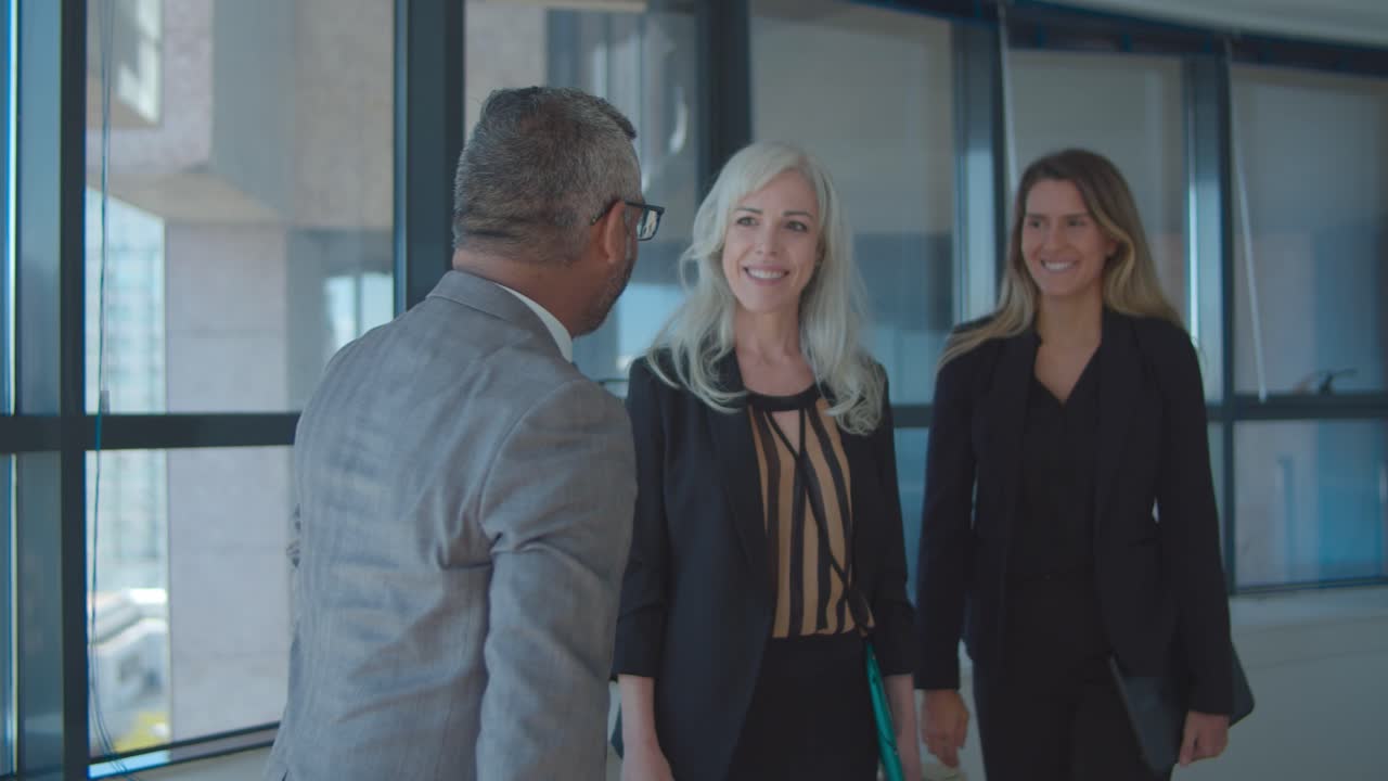 un hombre de negocios confiado se reúne con mujeres en su oficina.