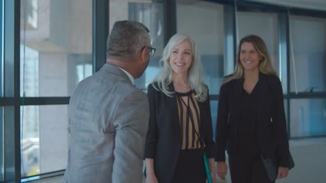 confident businessman meeting female partners in his office