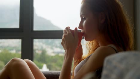 Woman-having-coffee-in-living-room-4k