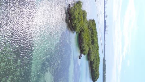 Vuelo-Vertical-Sobre-Un-Paisaje-Tropical-Con-Islas-Verdes-Y-Reflejo-Del-Sol-En-El-Agua