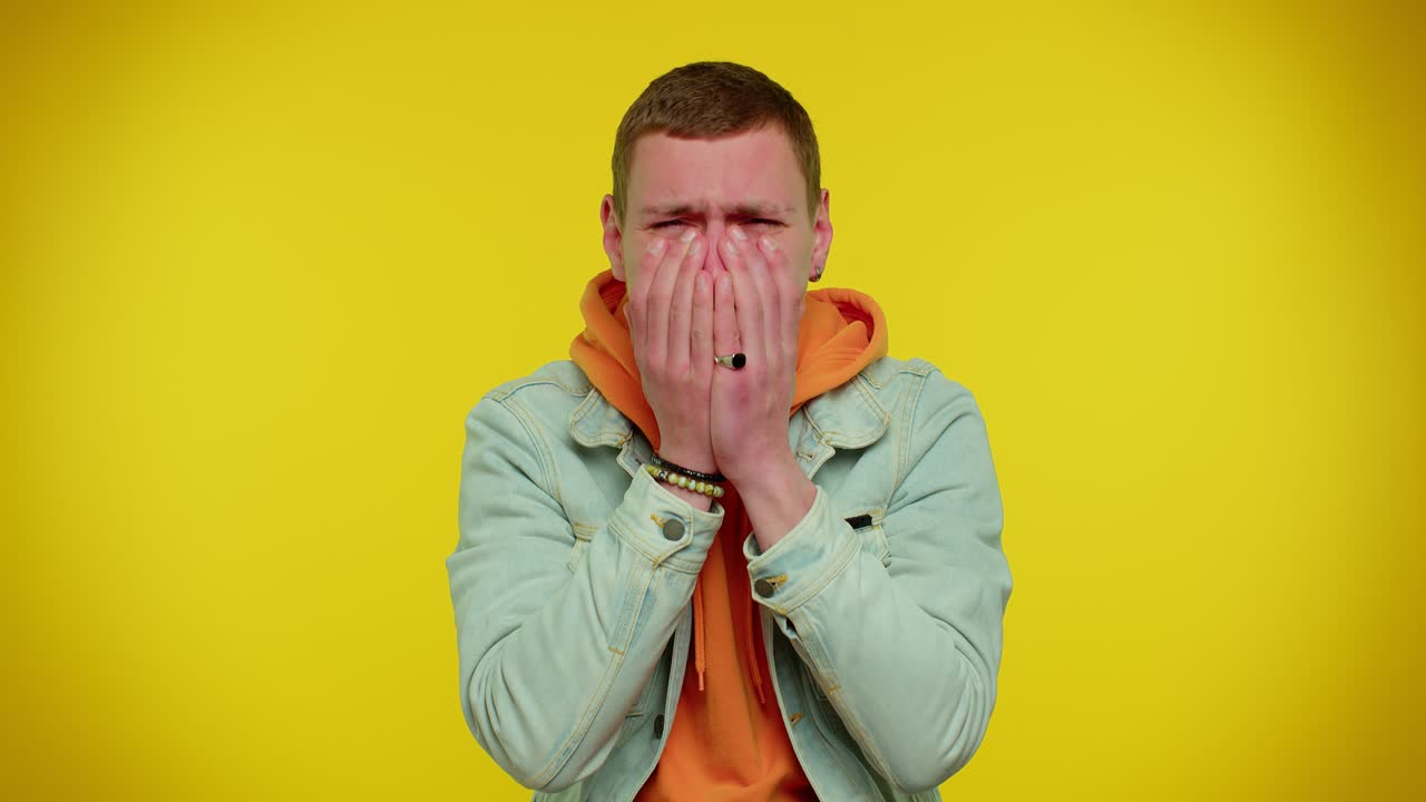 hombre llorando y mirando hacia abajo con tristeza