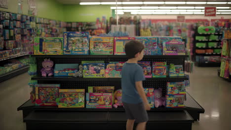 a young boy looks at toys in a store