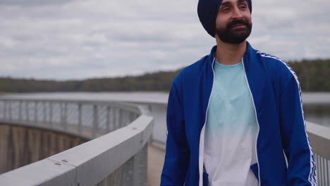 a punjabi sikhi man with mustache walking on the bridge