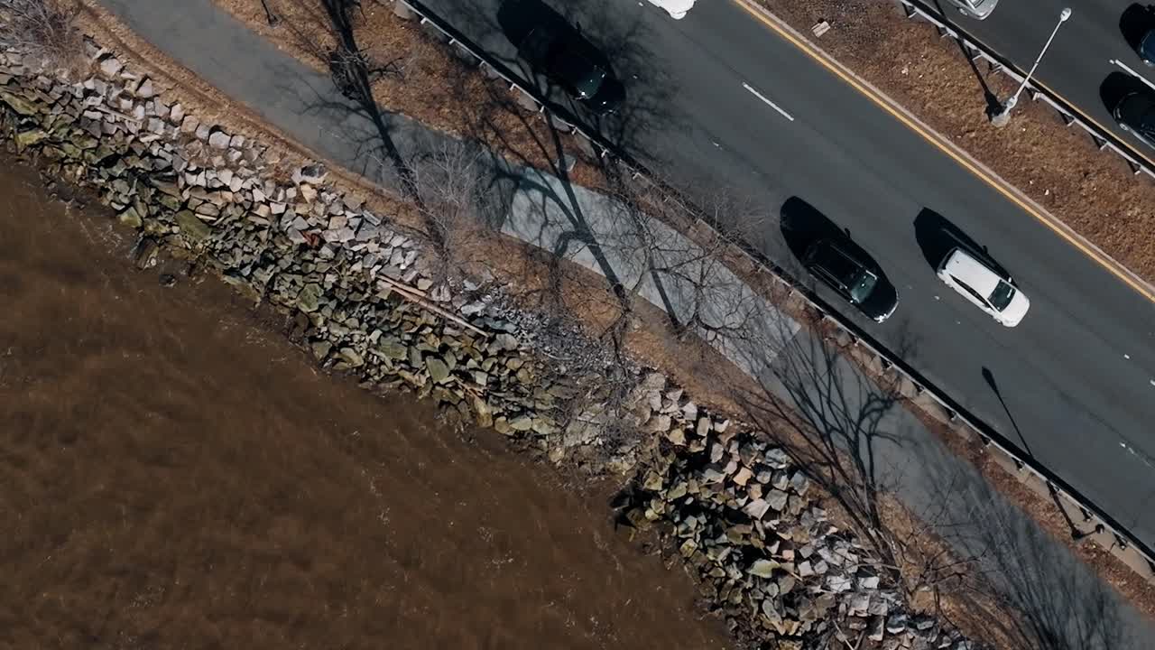 Biler, der kører langs vejen ved floden i New York, USA på en solskinsdag