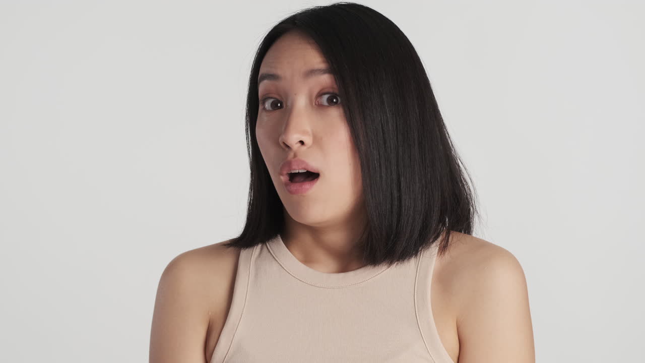 아시아 여성이 카메라 앞에서  놀랐다.