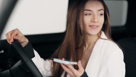 Retrato-De-Una-Mujer-Elegante-Con-Una-Chaqueta-Blanca-Hablando-Por-Teléfono-Mientras-Conduce-Un-Camión