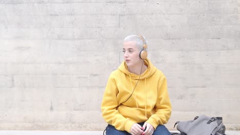 alternative caucasian female student listening to music with headphones