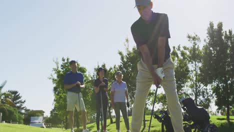 caucasian senior man practicing golf at golf course on a bright sunny day