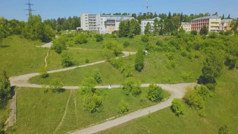 couple on path with hairpin curves on green hill aerial view