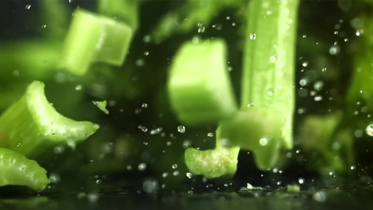 Water Splashing on Fresh Green Celery Pieces in Slow Motion