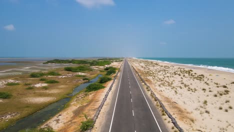 aerial drone shot of dhanushkodi, showcasing the dramatic meeting point of the bay of bengal and the indian ocean.