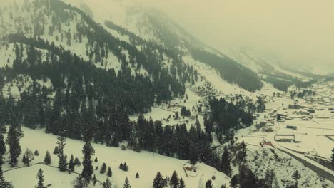 Aerial-View-Of-Snow-Covered-Naltar-Valley-Landscape-With-Trees-On-Hillside