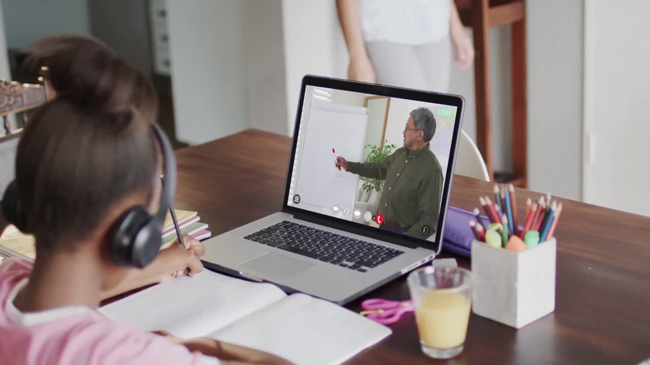 estudiante afroamericana en una computadora portátil aprendiendo en línea con un profesor masculino biracial