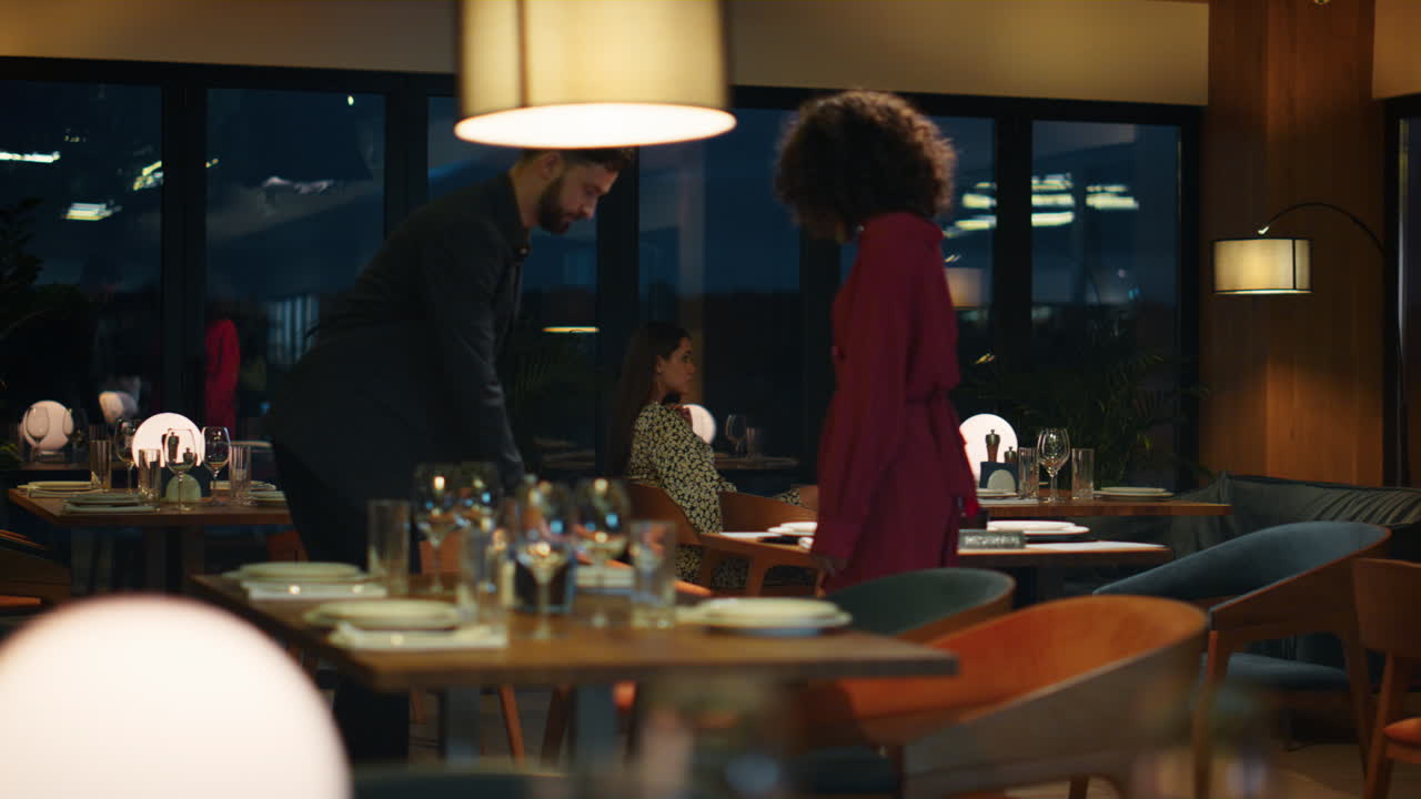 Mixed race lovers dating in night restaurant. Sexy couple enjoying time together