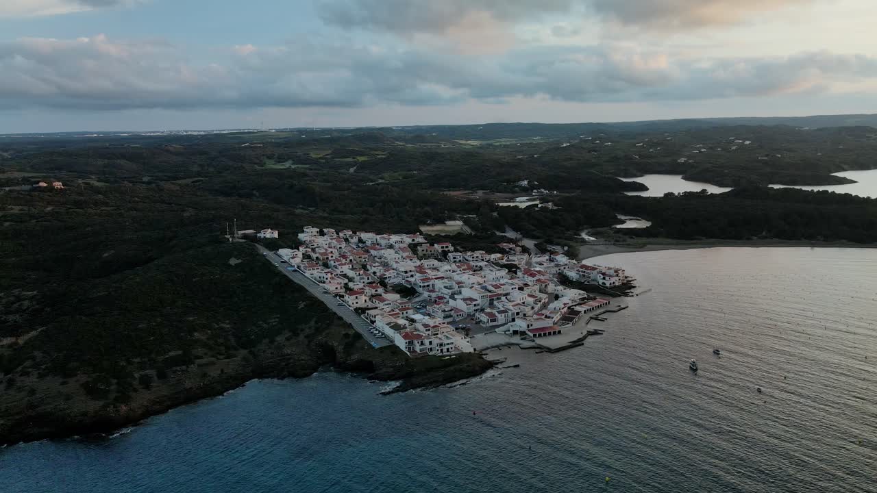 Luxury waterfront properties along the coastline of Menorca. Drone panning around town at sunset