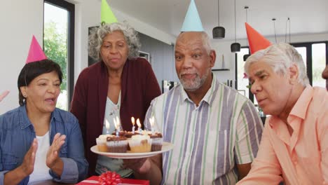 personas mayores felices y diversas en la fiesta de cumpleaños con pastel y regalos en la casa de retiro