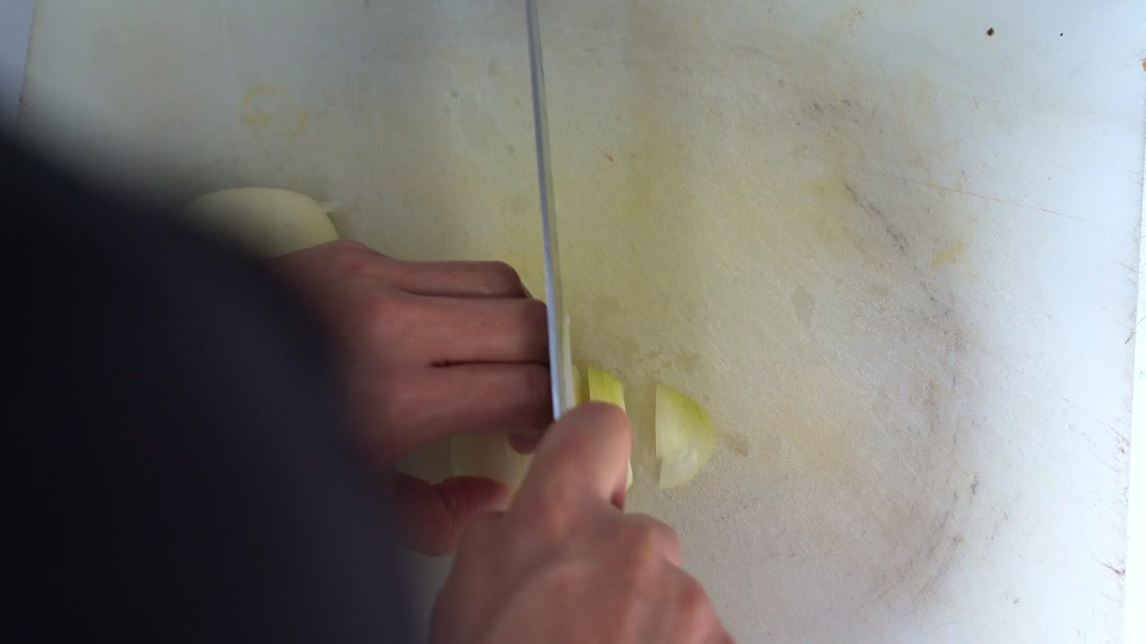 mano de cocina profesional, cortando brunoise cortando la cebolla, preparando los ingredientes para el funcionamiento del restaurante, toma de primer plano