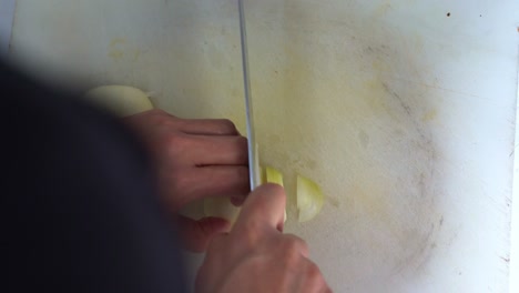 Professional-kitchen-hand,-slicing-brunoise-cut-the-onion,-preparing-the-ingredients-for-restaurant-operation,-close-up-shot