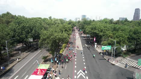 disparo rápido de dron hacia atrás de los corredores de la maratón de la ciudad mientras pasan por las grandes avenidas.