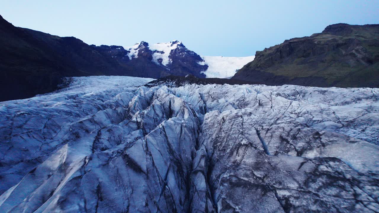 Aerial: View inside Glacier's serpentine path with deep crevasses and jagged ice formations, evidence of the climate change impact on the constant movement and transformation of this natural wonder