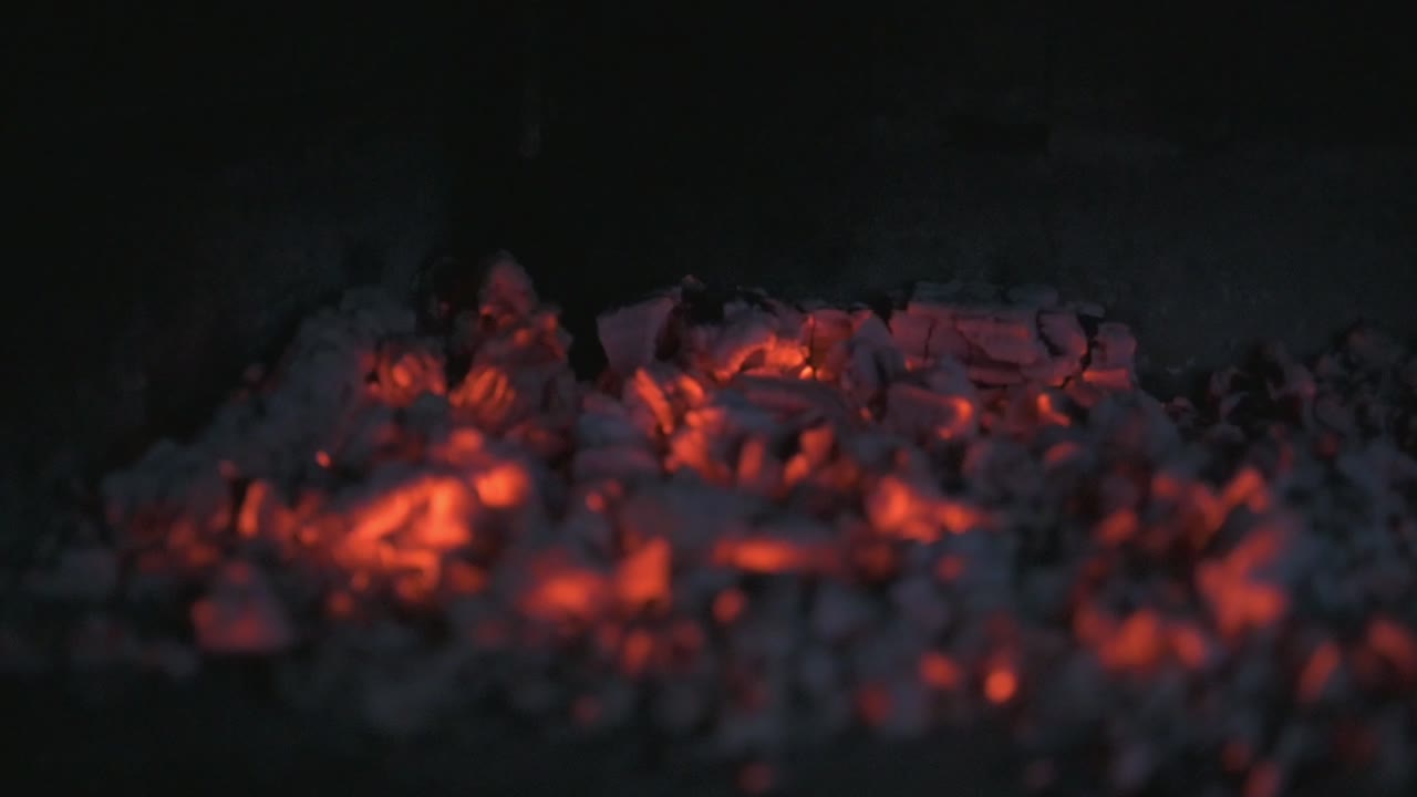 A fire burning in a stone furnace filmed