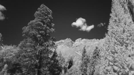 paisaje infrarrojo, lapso de tiempo de nubes en las montañas del cerro piltriquitron, patagonia, enmarcado por un árbol, tiro amplio