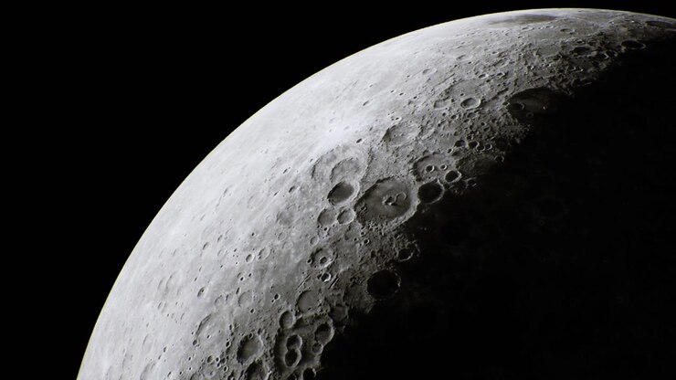 Superfície craterada da Lua lindamente exibida contra o céu negro profundo.