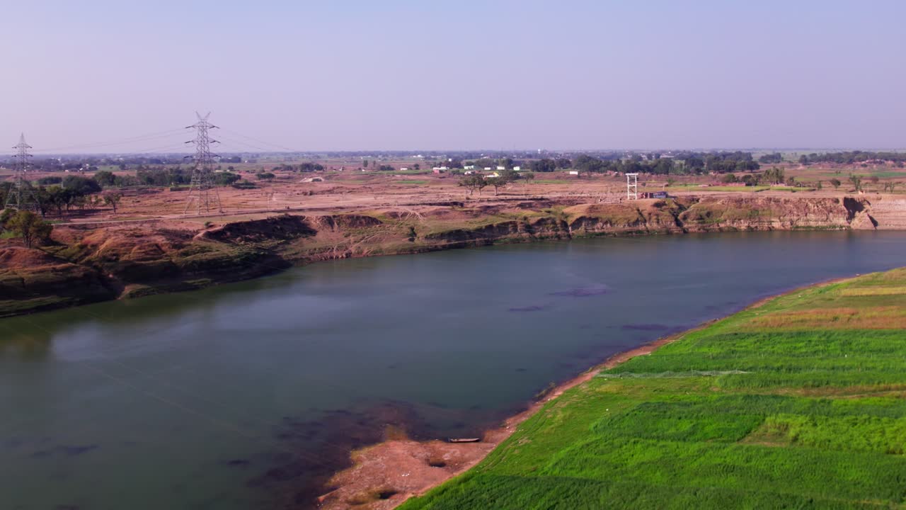 Crop fields lands with Narmada River and current pole at Jotpur, Jabalpur, madhya pradesh, india. day time, push in, drone shot, 4k.