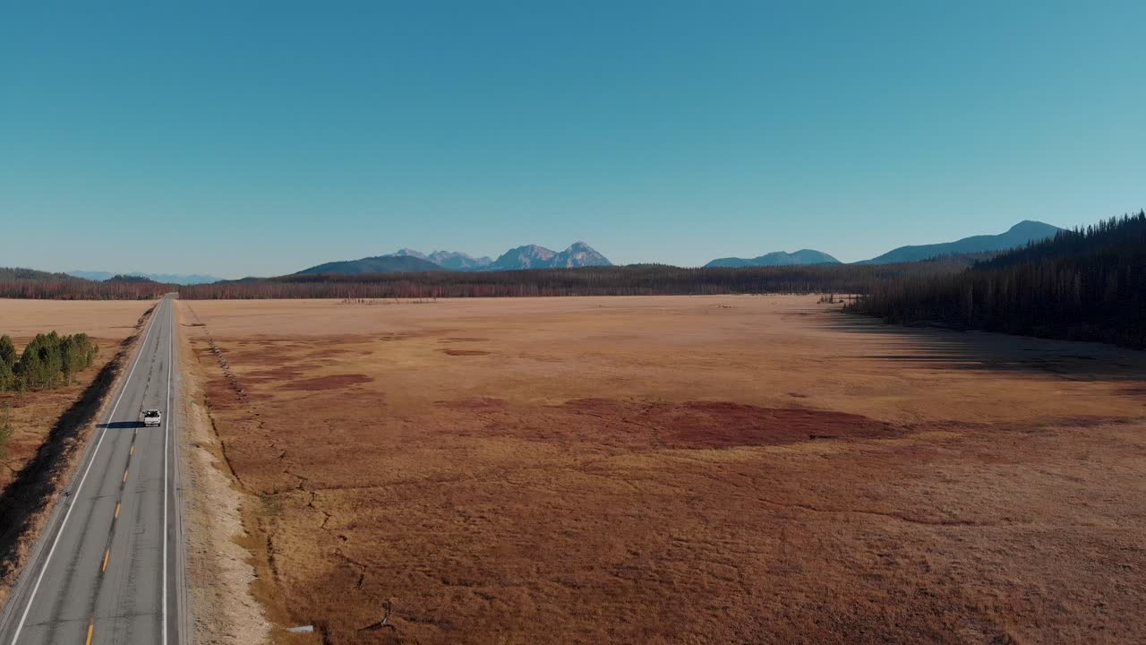 4k drone retrocede lentamente sobre campo abierto en las montañas de dientes de sierra, stanley idaho