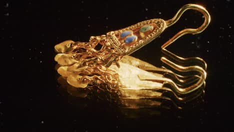pendiente de oro de una sacerdotisa escita de 2000 años de edad, un viejo pendiente, rueda giratoria, encontrado durante las excavaciones. joyas vintage. religión. primer plano