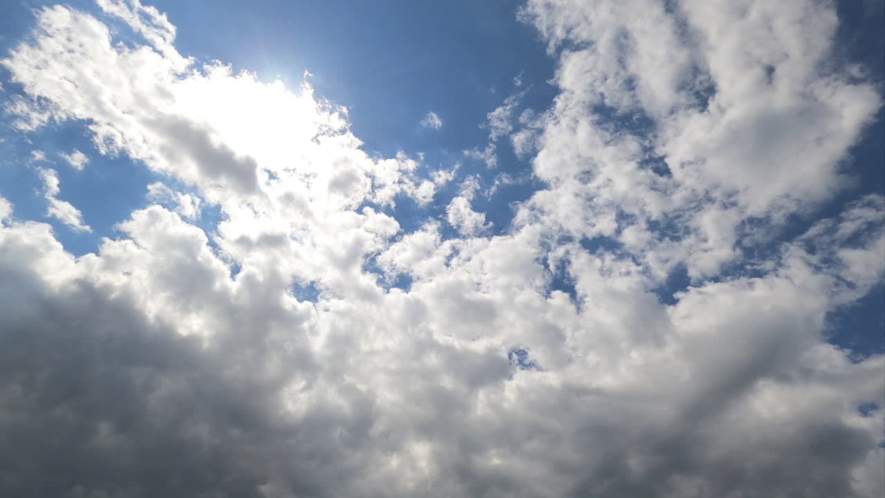 Rainy grey cloudscape go away uncovering the beautiful blue sky with shining sun. Timelapse. View from below.