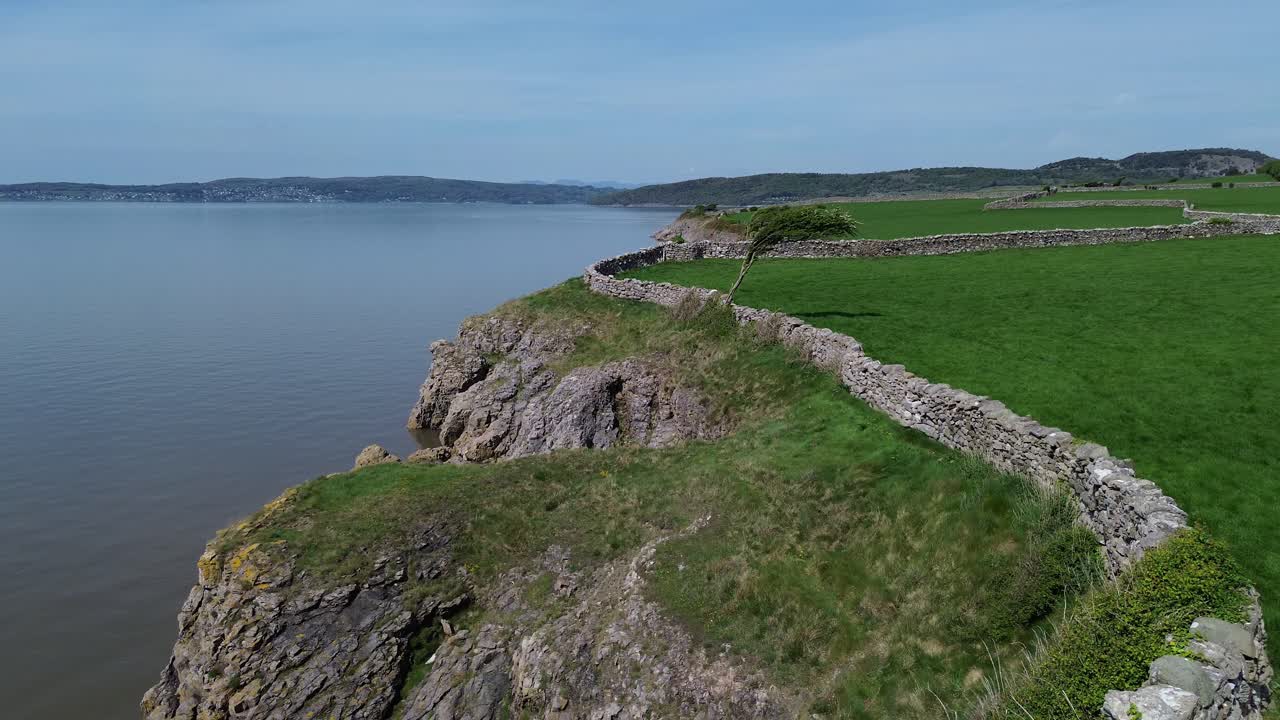 Lake district coastal farming pasture aerial view over stone wall boundary overlooking Morecambe bay
