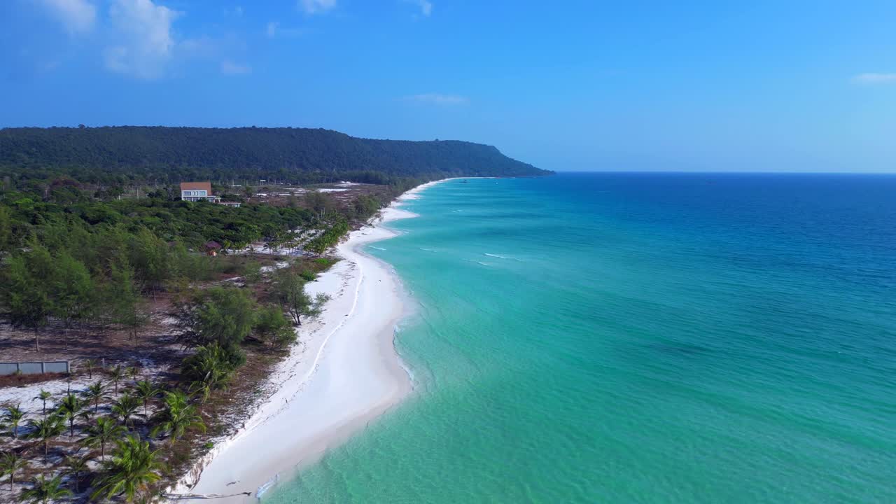 Crystal clear turquoise water gently lapping against a pristine white sand beach, lined with lush palm trees and a lone tourist enjoying the serene tropical paradise. aerial view fly reverse drone
