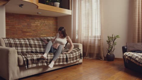 mujer embarazada relajándose en un sofá