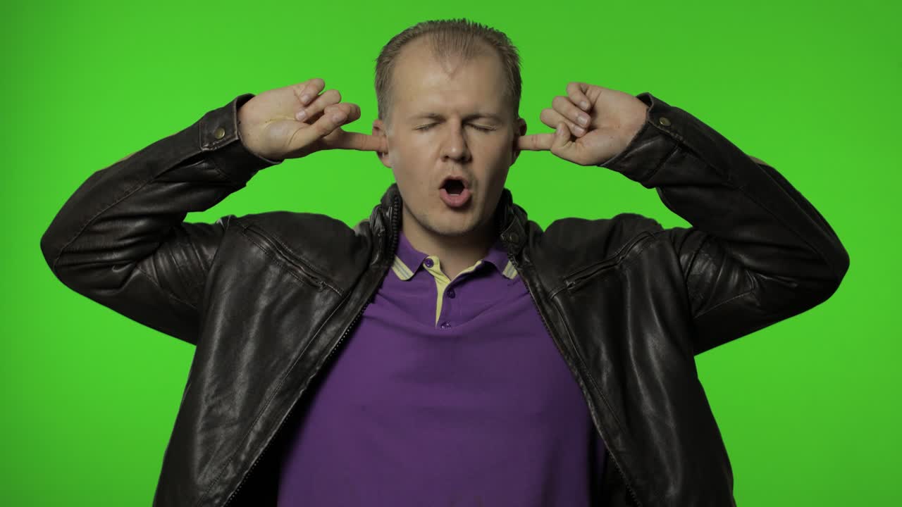 no quiero escuchar. rocker hombre cubriendo las orejas con los brazos para no escuchar conversación molesta, ignorando el conflicto