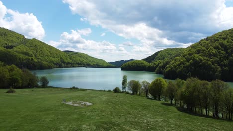 drone shot with turquoise lake water at mountain in the spring