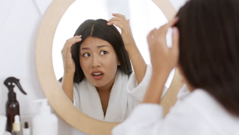 woman checking for hair loss in the bathroom
